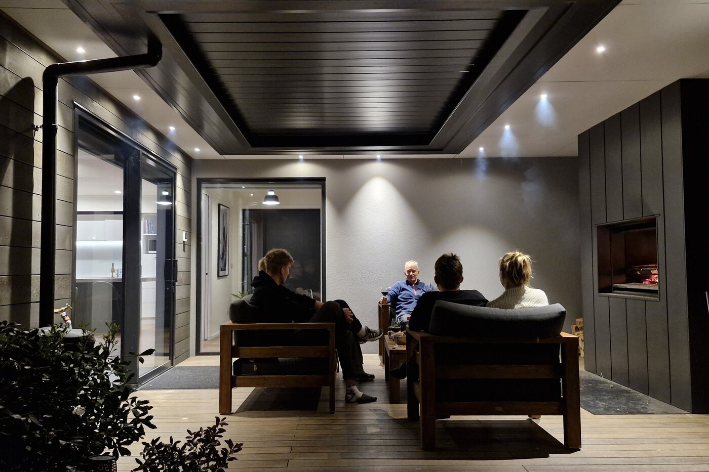 Covered outdoor room with a dark lined ceiling and recessed lighting